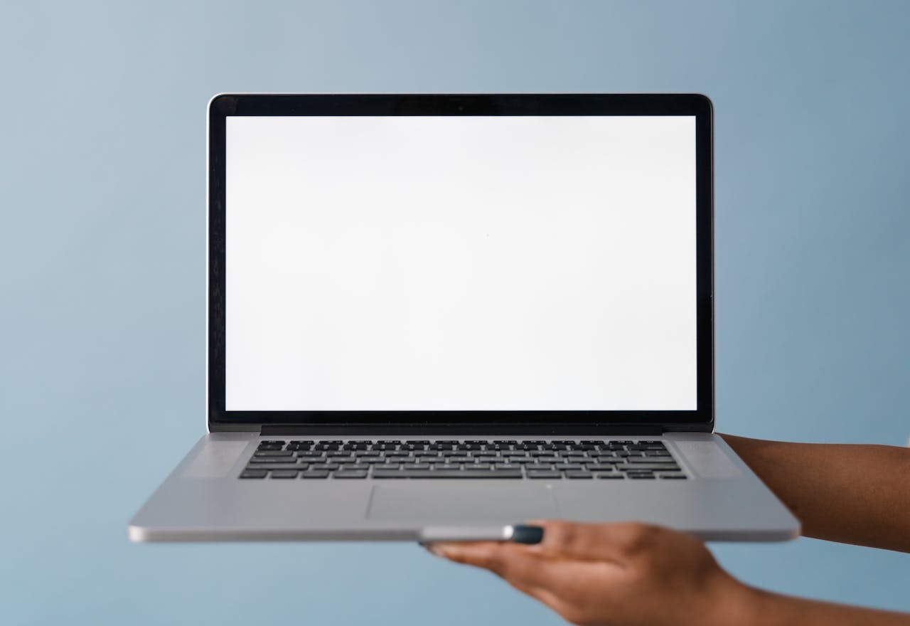 Close-up of a laptop held by a hand, perfect for tech product mockups with blue background.